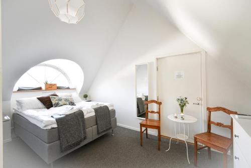 KåsebergaKåseberga Gårdshotell & Spa的白色卧室配有床和桌子