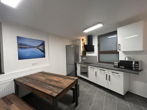 斯图加特Aparthotel Waldhorn Wohnung Allgäustyle的厨房配有木桌和冰箱。