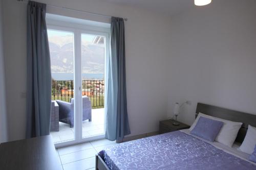 科利科Legnoncino Holiday Home- Lake Como的一间卧室设有一张床和一个滑动玻璃门