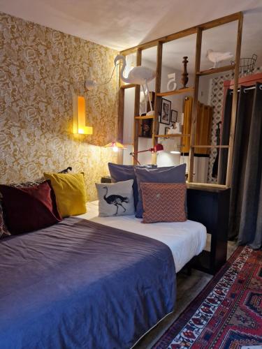 塔朗斯Sauveur le Sculpteur的一间卧室配有带色彩缤纷枕头的床。