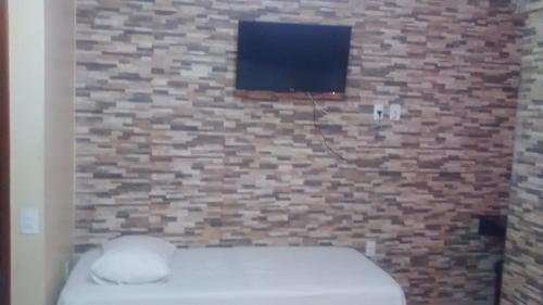 巴西利亚Hotel Dois Candangos的一间带砖墙、卫生间和电视的浴室