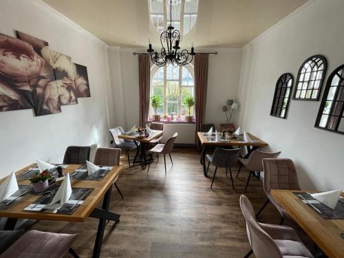 格拉登巴赫Suite Appartements Da Giovanni的餐厅设有木桌、椅子和窗户