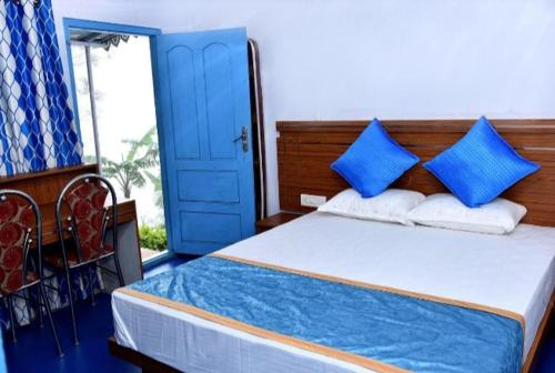 蒙纳Blackcherry Munnar的一间卧室设有蓝色门和一张带蓝色枕头的床