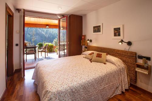 里波尔L'Adó的一间卧室设有一张床和一个滑动玻璃门