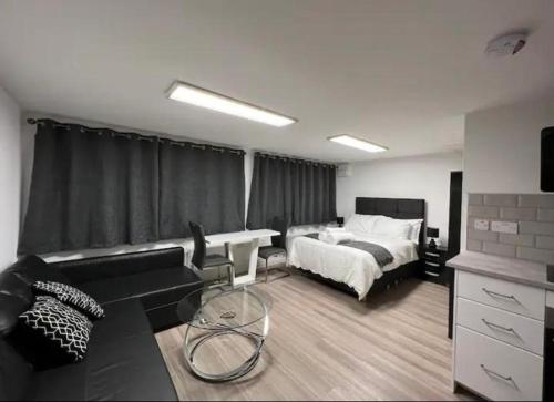 曼彻斯特Inviting 1-Bed Studio in Manchester & feel at home的一间卧室配有一张床,客厅配有沙发