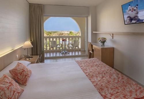 马塔拉斯卡尼亚斯科托大酒店的酒店客房设有一张床和一个阳台。