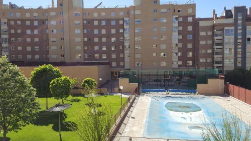 马德里Madrid Las Tablas apartments的一座空的游泳池,位于一座高楼城市