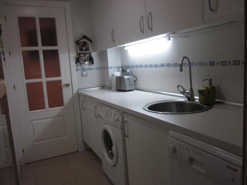 马德里Madrid Las Tablas apartments的厨房配有水槽和洗衣机