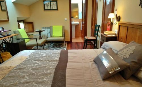 索托德卢伊尼亚萨斯维杰德尔萨斯特里酒店的一间卧室设有一张床,客厅设有绿色椅子