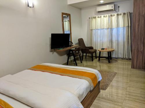 博卡拉甘塔维亚度假酒店的一间卧室配有一张床、一张书桌和一台电视
