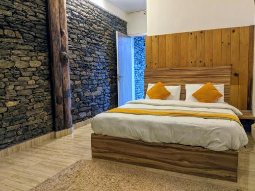 博卡拉甘塔维亚度假酒店的一间卧室设有一张大床和石墙