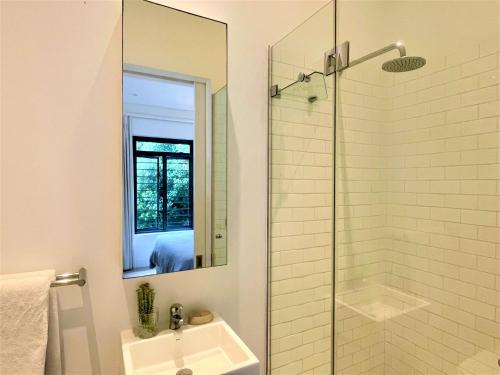 普利登堡湾Dageraad的浴室配有盥洗盆和带镜子的淋浴