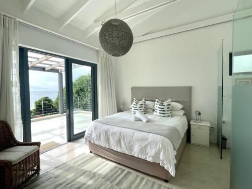 普利登堡湾Dageraad的白色的卧室设有床和大窗户