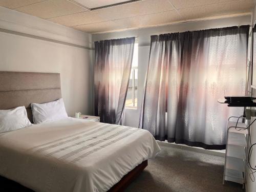 RandfonteinStay Inn Lodge Randfontein的一间卧室设有一张大床和一个窗户。
