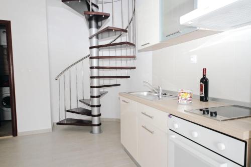 默克斯卡Apartments Du Lux的白色厨房内的螺旋楼梯,带水槽