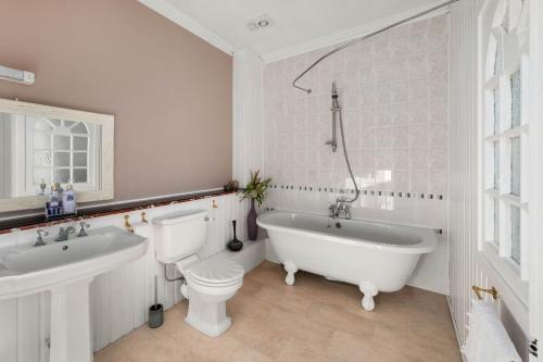 邓迪阿什利酒店的白色的浴室设有浴缸、卫生间和水槽。