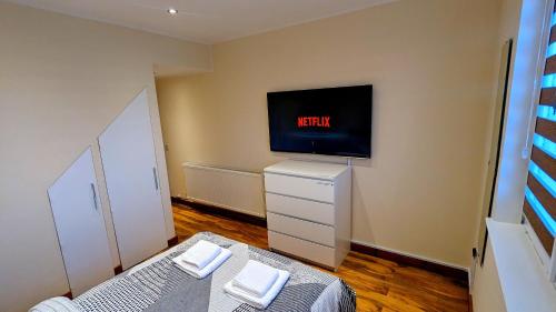 阿伯丁Private Room in Modern Apartment的卧室配有一张床,墙上配有电视。