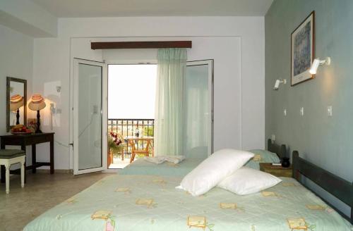 米蒂利尼Pygolampida Studios的一间卧室配有带枕头的床铺和阳台