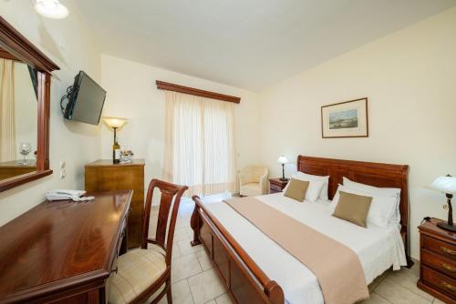 Ágios IoánnisAqualand Resort的酒店客房配有一张床、一张书桌和一张书桌。