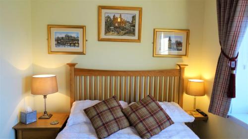 Port na LongBracadale House的一间卧室配有一张带两盏灯和两个枕头的床。