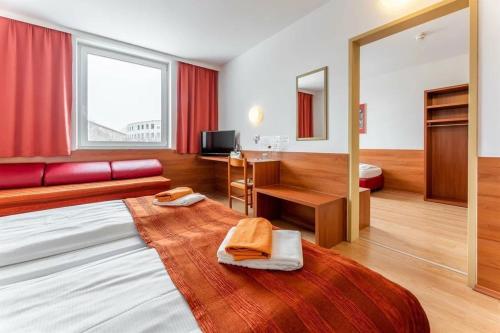 萨尔茨堡萨尔茨堡展览中心酒店的酒店客房配有床、书桌和水槽