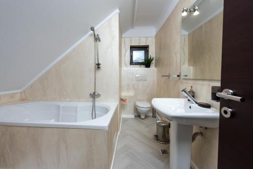 普雷代亚尔Infinity Villa的带浴缸和盥洗盆的浴室