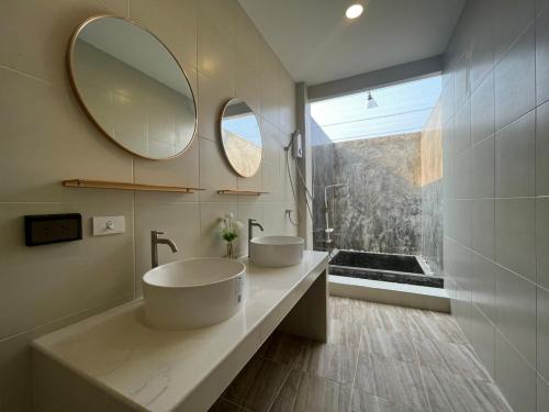 夜功府The PaVillu de Pool Villas的一间带两个盥洗盆和大镜子的浴室