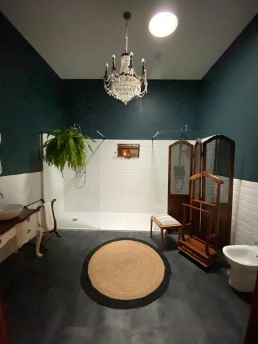 西尔韦斯Casa das Amendoeiras的一间带吊灯、水槽和镜子的浴室