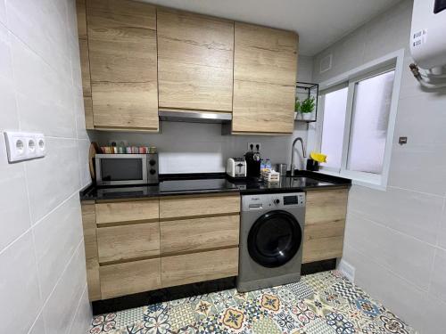奥伦塞Casa da Fonte的一个带洗衣机和微波炉的小厨房