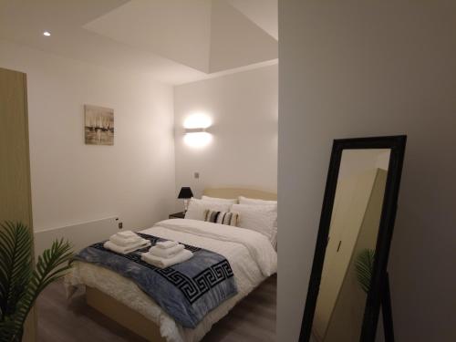 米尔顿凯恩斯Stylish 2 bedrooms, 2 bathrooms with workspace in Milton Keynes的一间卧室配有带毛巾的床