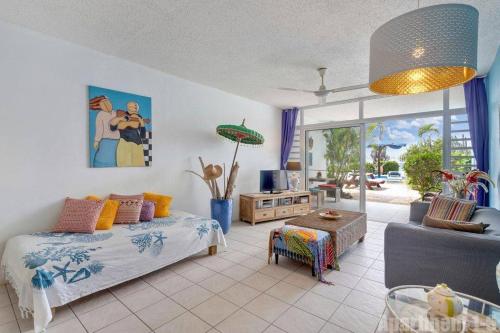 克拉伦代克博内尔岛海滨公寓的一间卧室设有一张床和一间客厅。