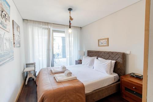 波尔图D João IV Apartment With Terrace by LovelyStay的一间卧室配有一张床,上面有两条毛巾
