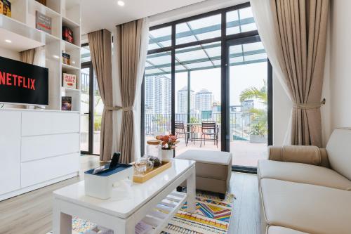河内LUCK APART 9 - Hanoi WestLake Balcony Apartment的客厅配有桌子和沙发