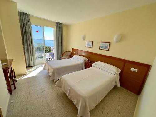 多列毛利诺斯Hotel Cabello的酒店客房设有两张床和窗户。