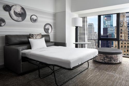 纽约纽约马奎斯万豪酒店的一间卧室配有一张床、一张沙发和一个窗口