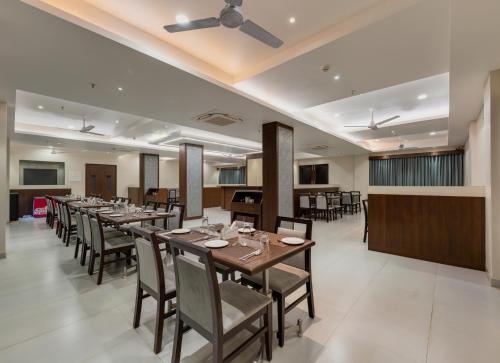 KudālHotel Aaradhya Adorer的一间带长桌和椅子的用餐室