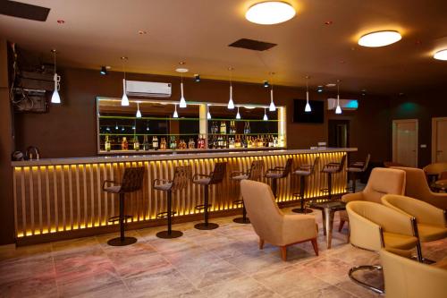 阿比让Hôtel les Vallons的餐厅内的酒吧配有椅子和柜台
