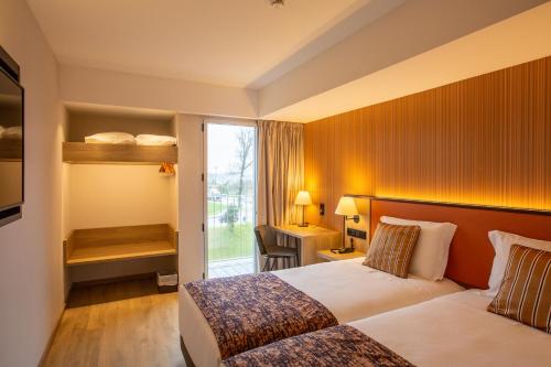 马亚Hotel 3K Porto Aeroporto的酒店客房设有两张床和窗户。