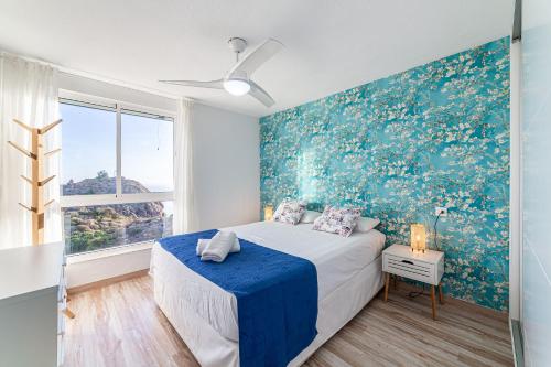 阿尔么丽亚Espejo del Mar的一间卧室设有一张床和蓝色的墙壁