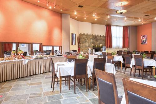 阿拉霍瓦Arahova Inn Hotel的一间设有白色桌椅的用餐室