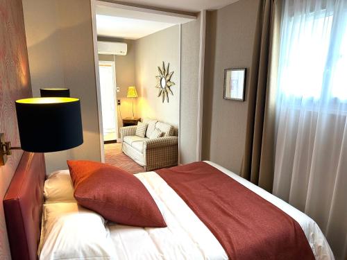 贝叶Churchill Hotel Bayeux Centre的一间卧室配有一张床,另一间卧室配有沙发。