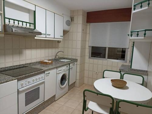 波多诺伏Apartamento Puente的厨房配有桌子和洗衣机。