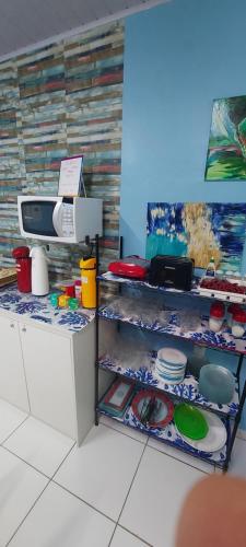 马瑙斯Hotel Colors Manaus的厨房配有带盘子和餐具的架子