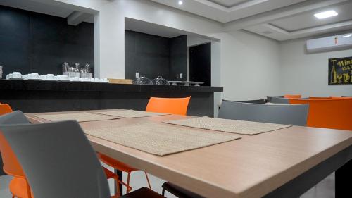 Santa InêsHotel Tupinambá的一间会议室,配有桌子和橙色椅子