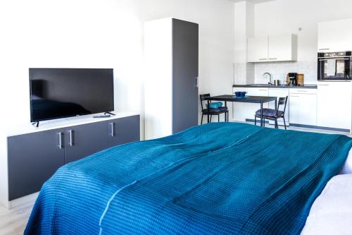 约阿希姆斯塔尔Ferienwohnungen direkt am Werbellinsee的一间带蓝色床的卧室和一间厨房