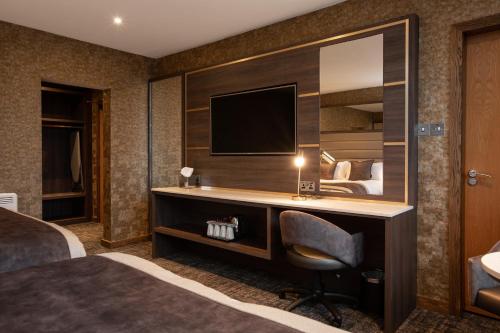 普雷斯蒂克卡尔登酒店的酒店客房配有书桌和电视。