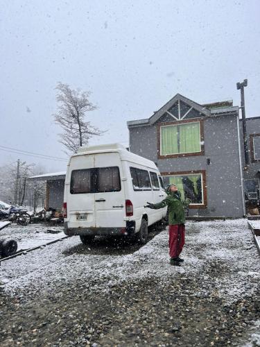 乌斯怀亚Caballo de Fuego的站在雪地里一辆面包车旁边的男人