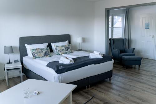卡珀尔恩北极光餐厅酒店的一间卧室配有一张大床和一把椅子