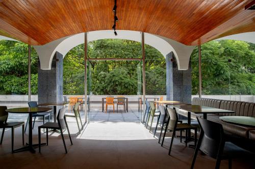 圣保罗Sooz Hotel Collection的餐厅设有桌椅和大窗户。