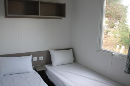 拉特斯mobil home au lac des rêves的一间设有两张靠窗的床的房间